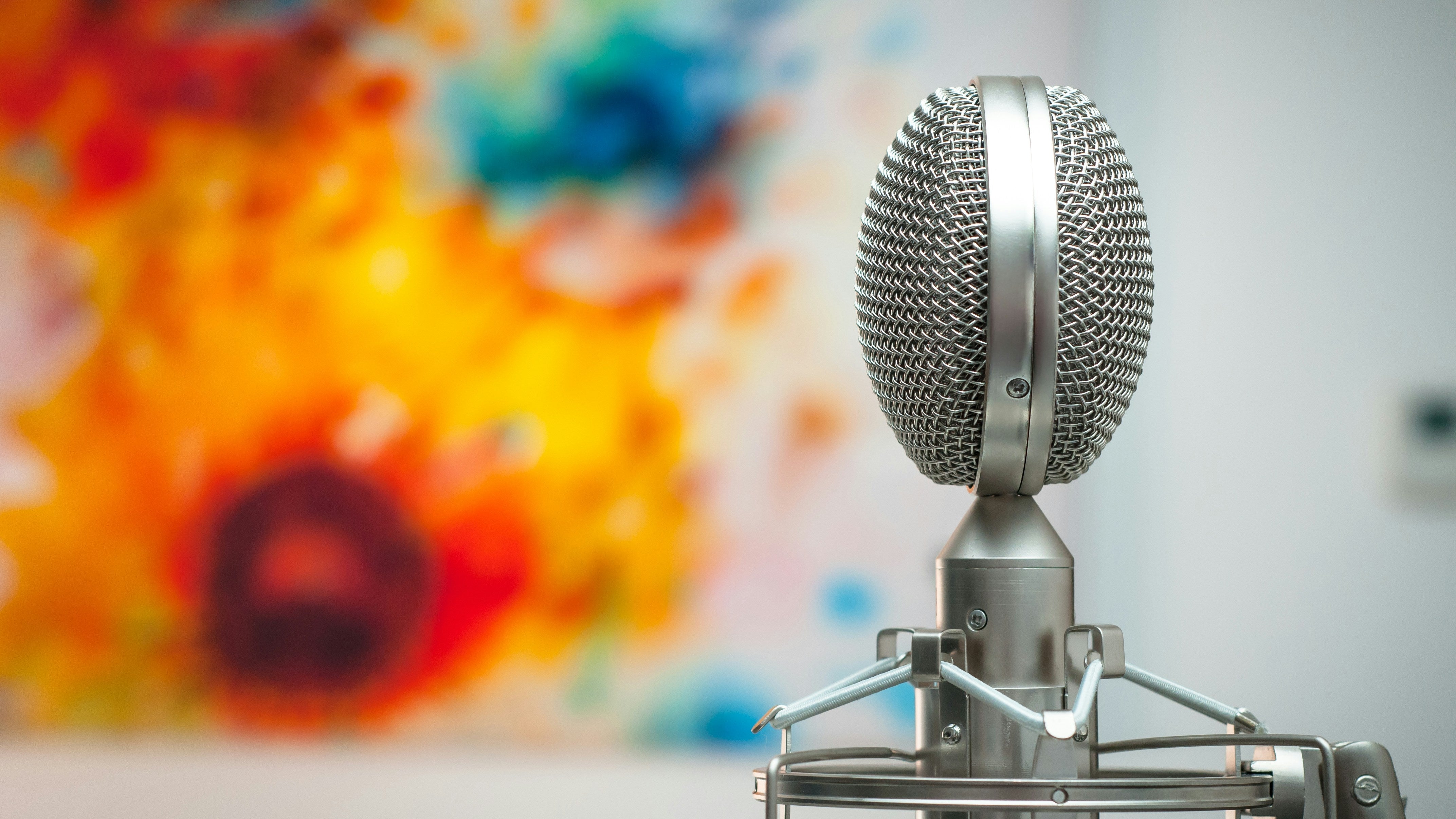 Microphone on a stand with a colorful abstract painting in the background